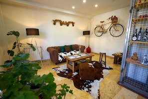 Sala de estar con sofá, mesa de centro y una bicicleta colgando.