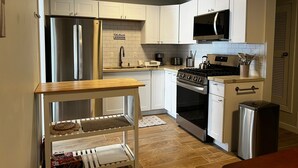 A compact kitchen with white cabinets, a stainless steel refrigerator, a microwave, a stove, and a sink. - Updated home strategically close to everywhere you want in El Paso and Cd Juárez (El Paso)