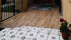 An outdoor patio with a wooden floor, a red umbrella, and a table with chairs. - Updated home strategically close to everywhere you want in El Paso and Cd Juárez (El Paso)