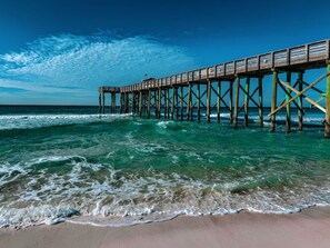 A pier extending into the ocean with clear skies.