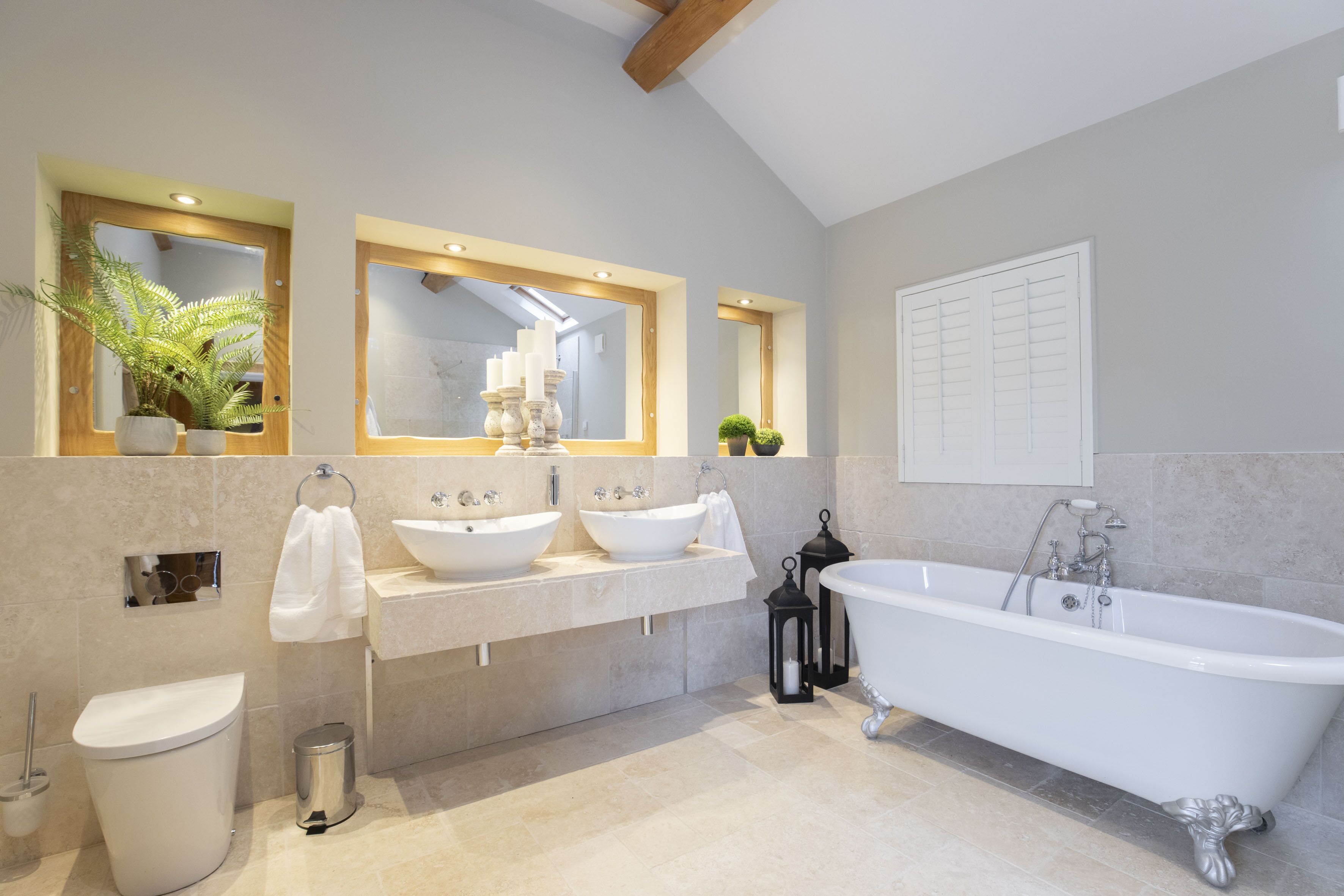 A modern bathroom with two sinks, a bathtub, and a toilet.