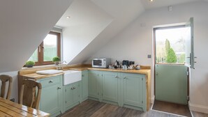 A kitchen with a wooden countertop, a sink, and cabinets. - Stable Lodge Boutique B&B (Cheltenham)