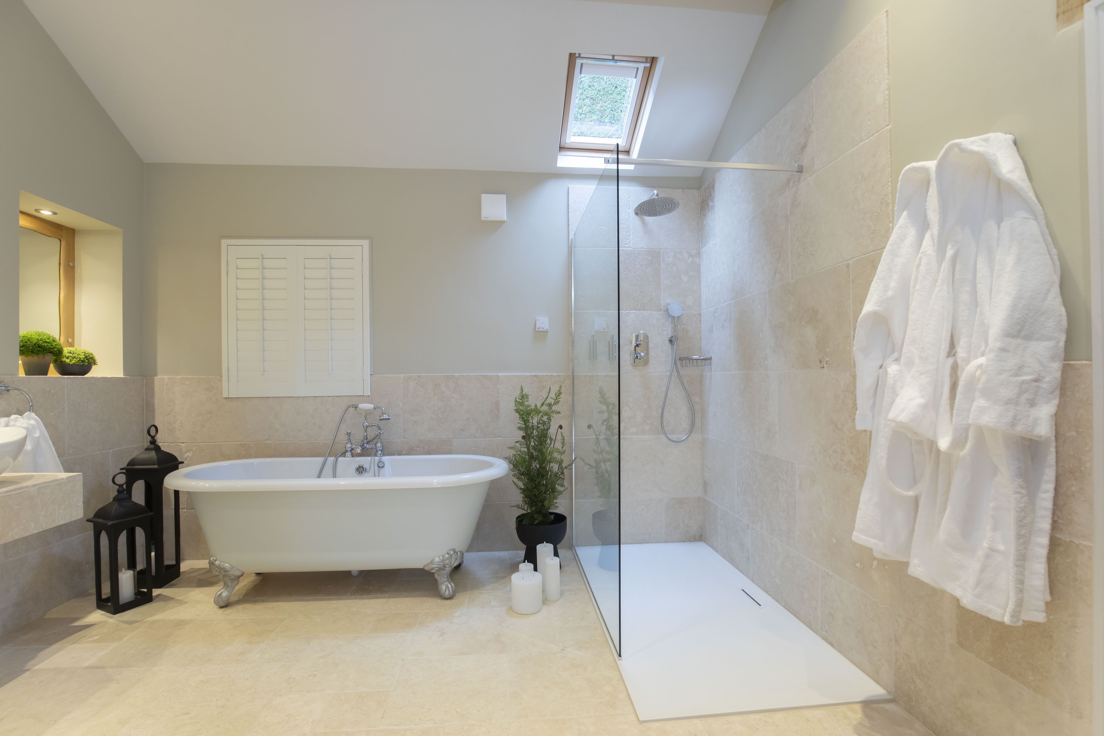 A modern bathroom with a freestanding bathtub, a glass-enclosed shower, and a white towel rack.