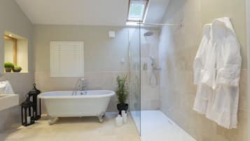 A modern bathroom with a freestanding bathtub, a glass-enclosed shower, and a white towel rack.
