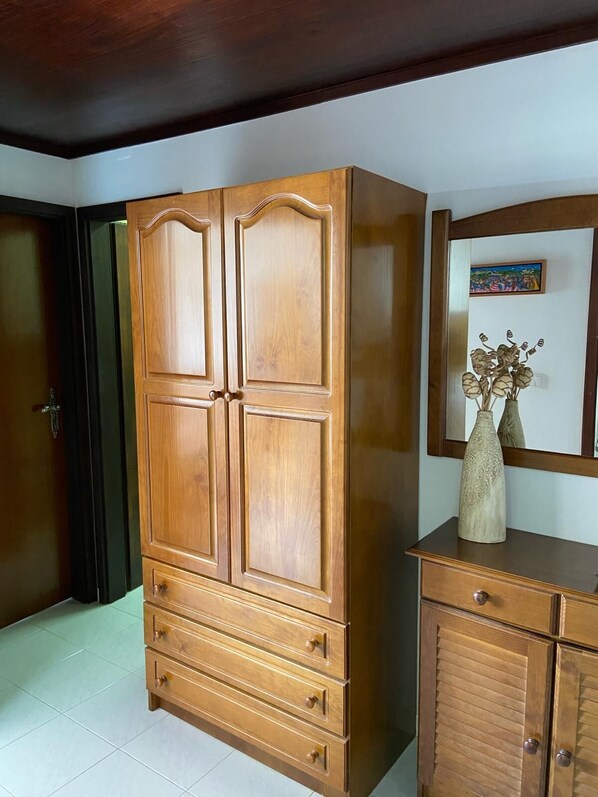 A wooden wardrobe with four drawers and a mirror above it.