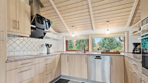 A modern kitchen with wooden cabinets, a dishwasher, and a window providing a view of the outdoors. - Awesome home in Ulfborg with kitchen (Ulfborg)