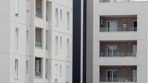 Un edificio de varios pisos con balcones, ventanas grandes y una estructura vertical central.