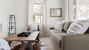 Un salon chaleureux avec une table en bois, un canapé et un tapis en peau de vache.