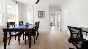 Un coin repas avec une table en bois, des chaises et un ventilateur de plafond.