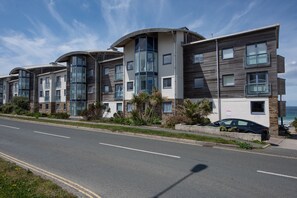 A modern multi-story residential building with balconies, large windows, and a coastal view. - Bathsheba, Ocean 1 - Parking - WiFi - Sea Views (Newquay)