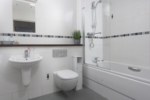 A modern bathroom with a sink, toilet, and bathtub. - Bathsheba, Ocean 1 - Parking - WiFi - Sea Views (Newquay)