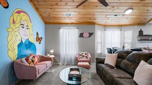 Una sala de estar con techo de madera, una mesa de centro de vidrio y dos sofás.