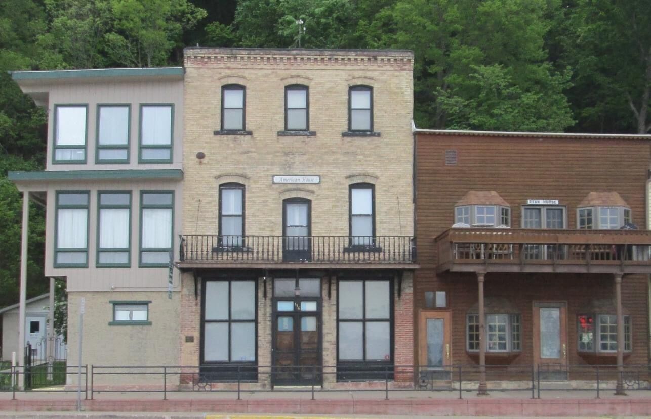 A row of three-story buildings with large windows and a central entrance.