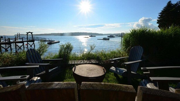 A lakeside view with dock, chairs, and a grill. - Berry Cottage, private dock, overlooking a sandy b (South Thomaston)
