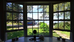 A bay window with a view of a house and a lake. - Berry Cottage, private dock, overlooking a sandy b (South Thomaston)