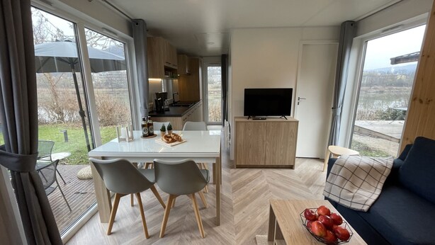 Un espace de vie moderne comprenant un coin repas, une cuisine et un coin salon.