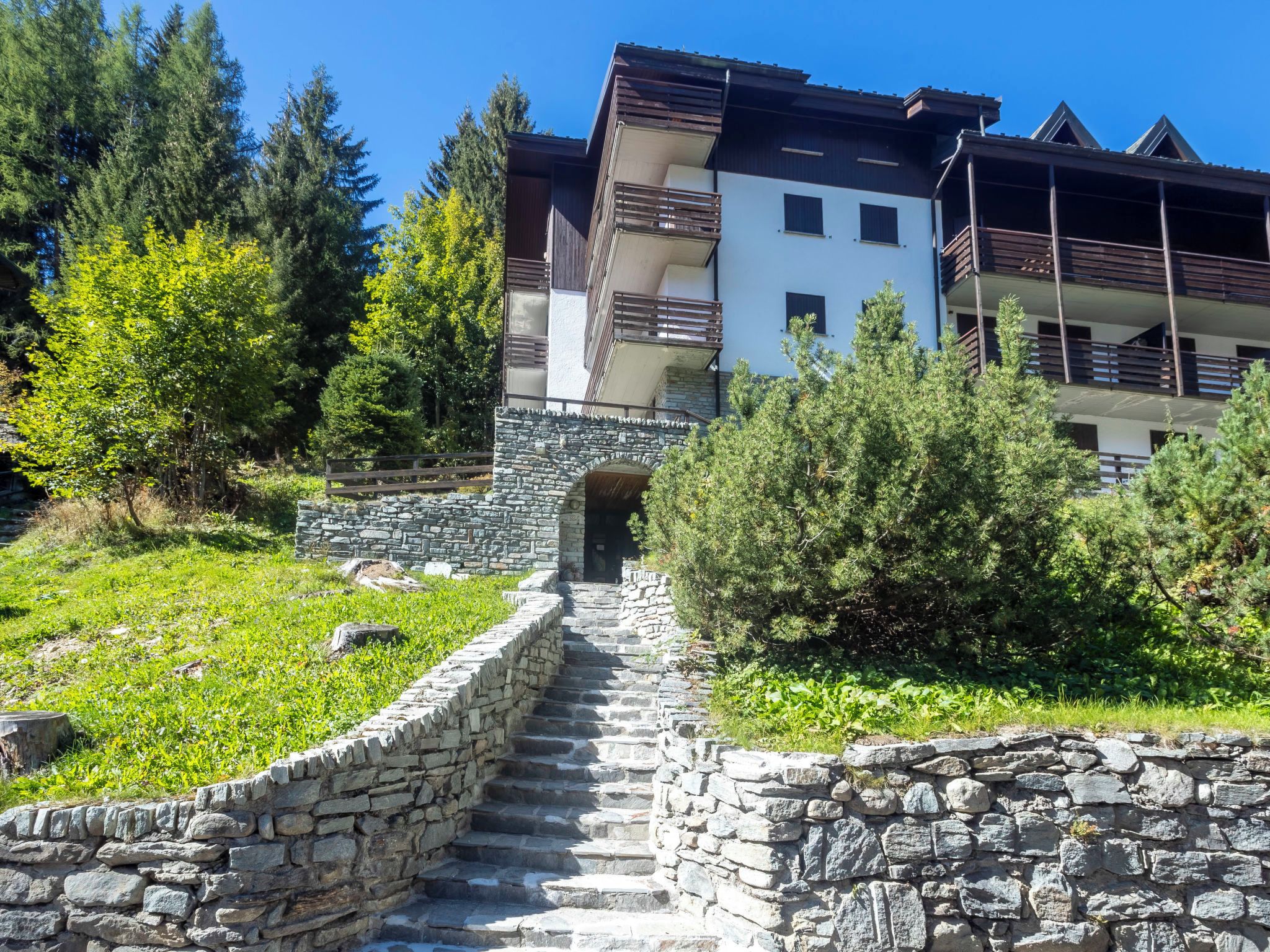A stone staircase leading to a building with multiple balconies.