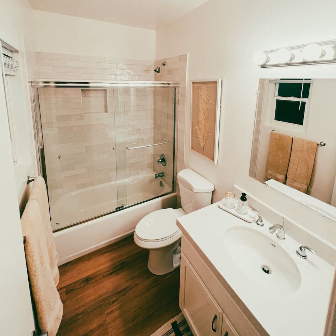 Un bagno moderno con doccia a vetro, un water, un lavandino e uno specchio.