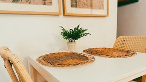 A white dining table with two woven placemats, surrounded by wicker chairs. - Walk to Beach! Entire SC Triplex (San Clemente)