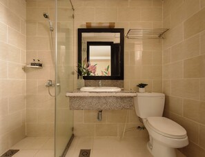 A bathroom with a glass-enclosed shower, a sink with a mirror above it, and a toilet. - Asian Ruby Hotel & Apartment (Ho Chi Minh City)