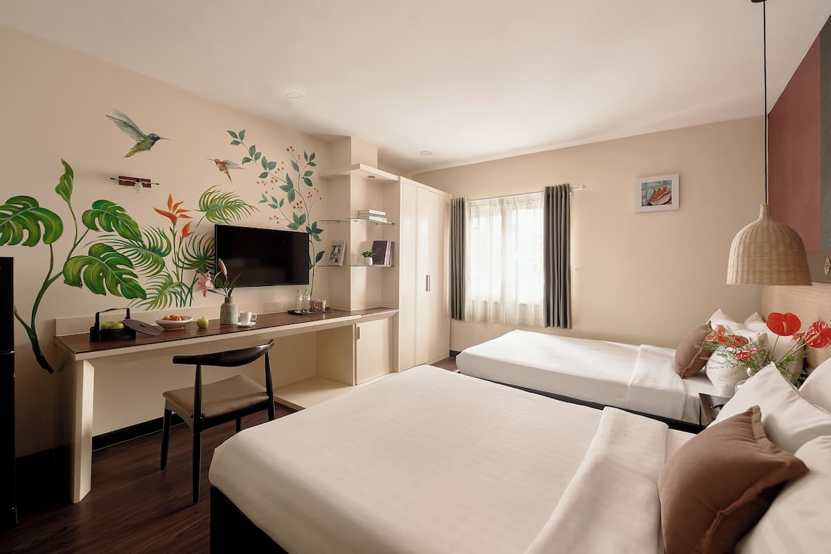 Une chambre d’hôtel avec un lit, un bureau et une chaise, une télévision et une fenêtre avec des rideaux.