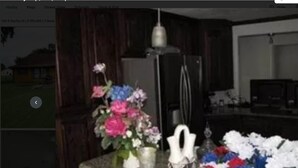 A kitchen with a countertop, a vase with flowers, and a refrigerator. - Beautiful 3Beds in Bridge City! (Bridge City)