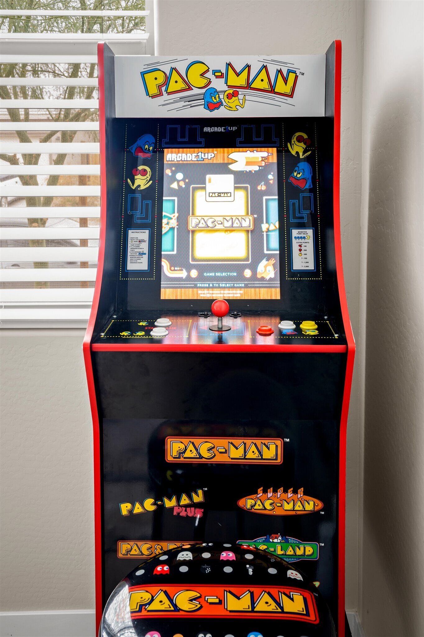 A Pac-Man arcade machine with a selection screen and game controls.