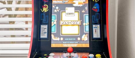 A Pac-Man arcade machine with a selection screen and game controls.