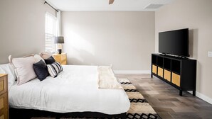 A bedroom with a bed, a ceiling fan, a television, and a nightstand. - 3 BR home w/Pool & Game room (Phoenix)