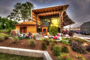 A modern building with a wooden exterior and a covered outdoor seating area.