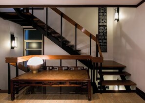 A staircase with a wooden handrail and a wall-mounted sign listing street names. - Katamanda Villa Aliya Jacuzzi Pool near Kata Beach (Karon)