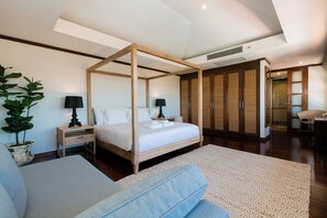 A modern bedroom with a four-poster bed, wooden wardrobe, and a large potted plant.