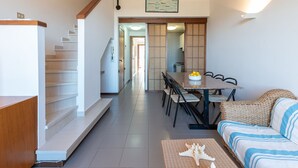 A spacious living area with a dining table, sofa, and staircase leading to an upper floor. - I Boboli by Interhome (Punta Ala)