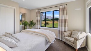 Une chambre à coucher avec un grand lit, une chaise et une fenêtre donnant sur un paysage.
