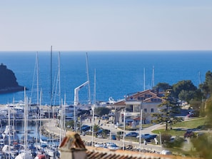 A marina with multiple sailboats docked, a restaurant, and a reception area.