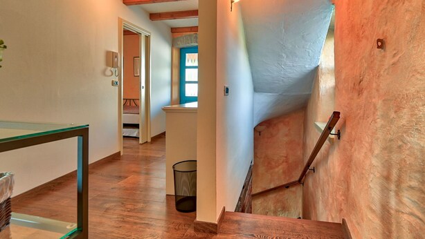 A staircase with wooden steps and a metal handrail, leading to a landing with a door and a window. - Vacation home Simone by Interhome (Poreč/Žbandaj)
