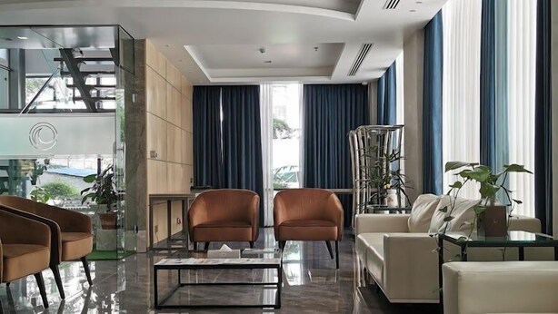 A modern hotel lobby with a glass coffee table, leather armchairs, a sofa, and a large window with blue curtains. - Pearl Hotel Dhaka (Dhaka)