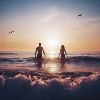 Atardecer sobre el océano con dos personas de pie en el agua.