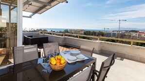 A balcony with a glass table, chairs, and a bowl of fruit. - Luxury Atic Cambrils by Interhome (Cambrils)
