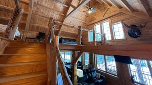 A wooden interior with a staircase, a ceiling fan, and a mounted animal head. - Prong Pond Cabin*Water Access*Pet Friendly*Snowmobile Access (Greenville)
