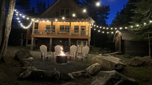 A cabin with a deck, outdoor seating, and a fire pit. - Prong Pond Cabin*Water Access*Pet Friendly*Snowmobile Access (Greenville)