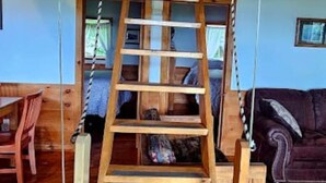 A wooden ladder suspended from the ceiling in a room with wooden walls and a ceiling beam. - Seboomook-Lake/Mountain Views*Shared Dock*Kayaks*Hiking Trails*A/C (Greenville)
