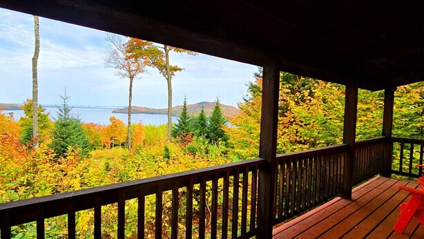 A wooden deck with a view of autumn foliage and a body of water. - Seboomook-Lake/Mountain Views*Shared Dock*Kayaks*Hiking Trails*A/C (Greenville)