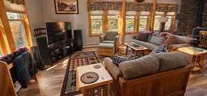 A cozy living room with a television, seating area, and a fireplace.