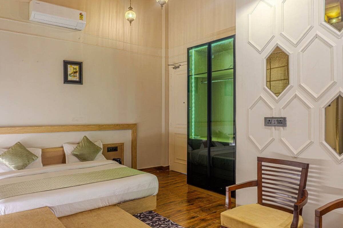 A bedroom with a wooden bed, a chair, and a green-lit door.