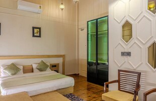 A bedroom with a wooden bed, a chair, and a green-lit door.