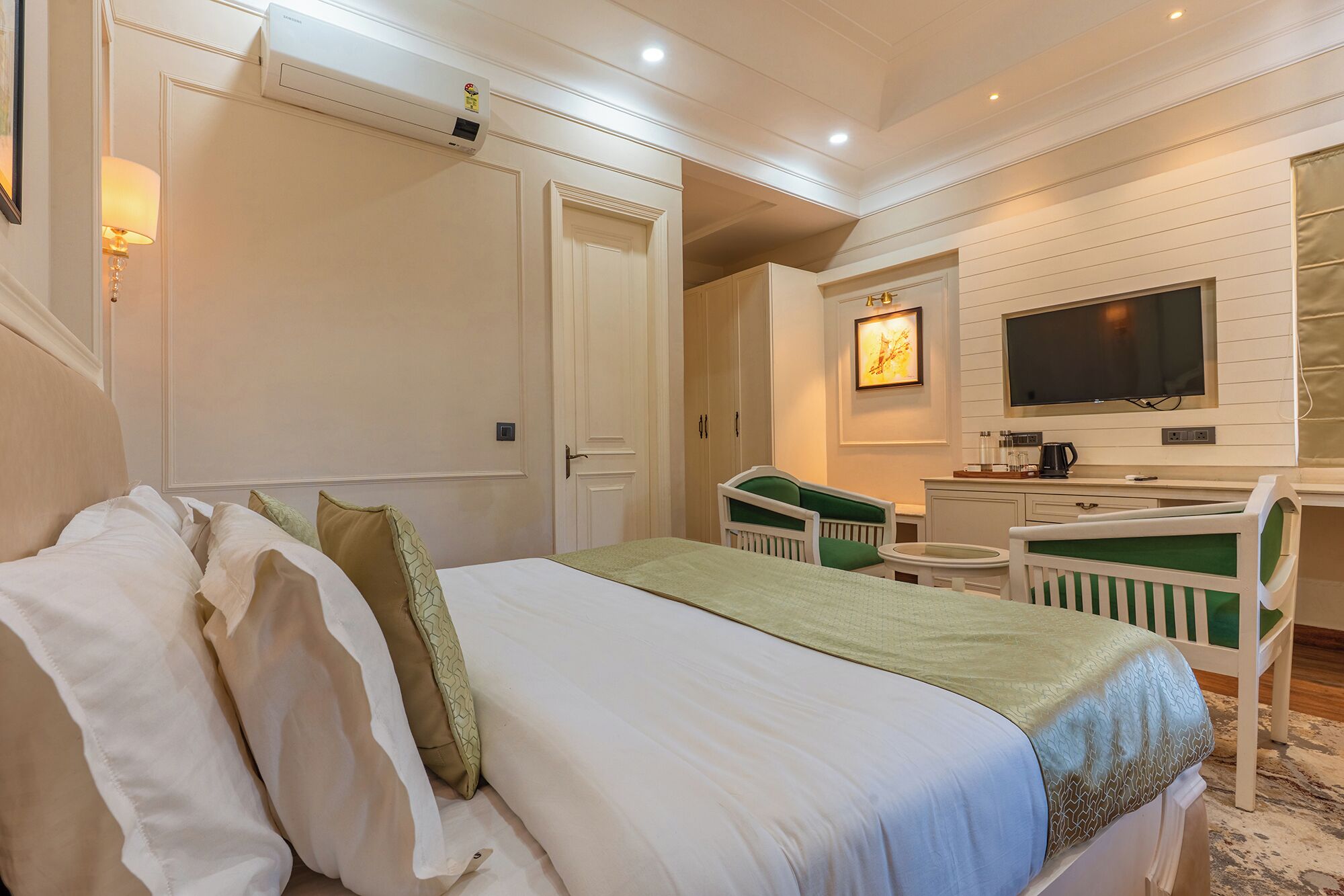 A hotel room with a bed, a desk, a chair, a television, and a bathroom.