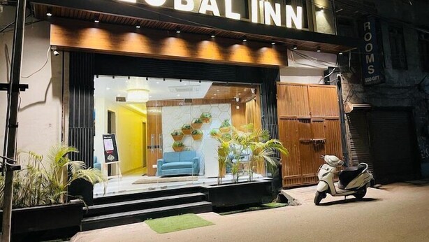 The exterior of Hotel Global Inn, featuring a modern facade, a reception area with a blue sofa, and a scooter parked outside. - Hotel Global Inn (Amritsar)