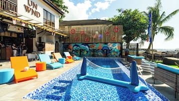 Una piscina al aire libre, sillones reclinables de piscina