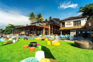 Un resort tropical con asientos exteriores, un restaurante y un bar.